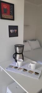 a tray with two cups and a mixer on a table at Refúgio ensolarado a poucos passos do mar in Navegantes