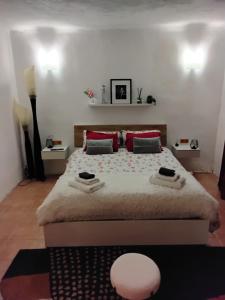 a bedroom with a large bed with red pillows at Alpine's Apartment in Arnoldstein
