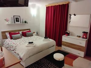 a bedroom with a bed and a red curtain at Alpine's Apartment in Arnoldstein