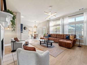 a living room with a couch and a table at Boho Dreamscape 4BD Game Room Pool in The Colony