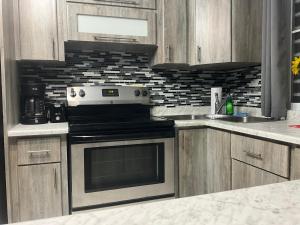 a kitchen with wooden cabinets and a stove top oven at Jobos Family Condos in Isabela