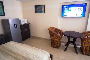 a room with a bed and a table and a refrigerator at Rancho Percebu Beach Studio 4 in San Felipe
