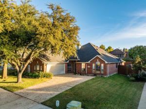 a red brick house with a garage at Boho Dreamscape 4BD Game Room Pool in The Colony