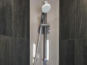 a shower head in a bathroom next to a wall at Ibis Aktobe in Aktobe