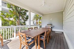 a porch with a wooden table and chairs at It's a Shore Thing in Inlet Beach