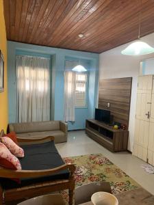 Una sala de estar con un sofá y un televisor. en Casa bela, en Lauro de Freitas