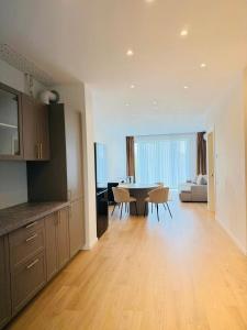 a kitchen and living room with a table and chairs at Roots One - Lakeview Escape with Balcony & Parking in Bucharest