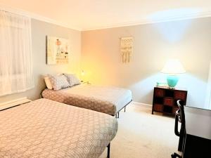 a small bedroom with two beds and a lamp at Modern Condo in Laconia, Pool, Balcony & Parking in Laconia