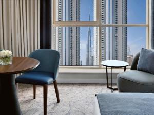 Una habitación con una mesa y sillas y una ventana grande. en Mövenpick Hotel Apartments Downtown Dubai, en Dubái