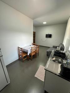 Zimmer mit einer Küche mit einem Tisch und einem Esszimmer in der Unterkunft Casa garagem camionete, 2 quartos, espaço para 6 pessoas, casa completa, 5min Centro - Casa 5 in Sinop