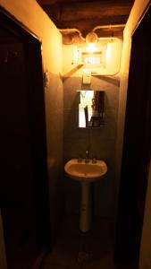 a small bathroom with a sink and a mirror at Cabañas rainbow in San Marcos Sierras
