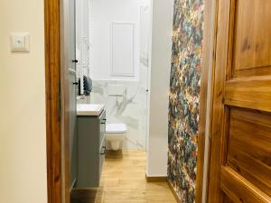 ein Badezimmer mit Toilette und Waschbecken und einer Tür in der Unterkunft Apartament Ratuszowy in Wałbrzych + 31 Fotos