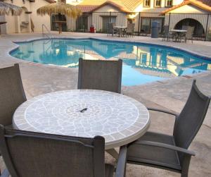 a table and chairs in front of a swimming pool at San Felipe Luxurious 3-Bedroom Condo 11-3 with Pool Access in La Ponderosa