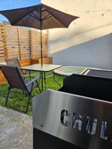 a grill with an umbrella and a table and chair at Loft Sp in San Pedro