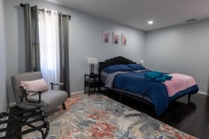 ein Schlafzimmer mit einem Bett und einem Stuhl in der Unterkunft New Apt Lake Park Station EWR Airport Path Train Subway Bus Hospital NJ NYC in Rahway