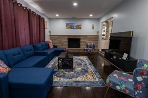 ein Wohnzimmer mit blauen Sofas und einem Kamin in der Unterkunft New Apt Lake Park Station EWR Airport Path Train Subway Bus Hospital NJ NYC in Rahway