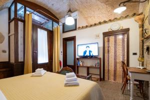 a room with two beds and a table and a tv at L'Alcova dei Grifoni in Ascoli Satriano