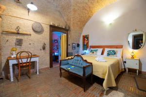 a bedroom with a bed and a desk and a chair at L'Alcova dei Grifoni in Ascoli Satriano