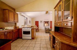a kitchen with wooden cabinets and a white stove top oven at 3 bedroom Beach side home away from home in San Felipe