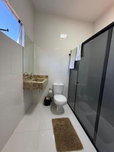 a bathroom with a toilet and a sink and a shower at Pousada Essencia de Pipa in Pipa