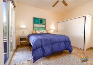a bedroom with a bed with a blue comforter at Casa Desert Rose - Gated Community San Felipe Vacation Rental Home in Playa Hawaii