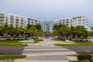 a park with palm trees in front of a building at Relax Loft on the beach Town Center Playa B in Río Hato