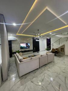 イケジャにあるSerenity Villa Ikejaのソファとテレビのある広いリビングルーム +6枚の写真