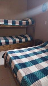 two bunk beds in a room with a checkered blanket at El Shaddai I in Santiago del Estero