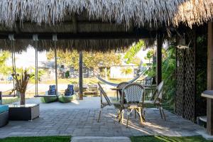 a patio with chairs and a table and a straw umbrella at Ocean Pearl Hudson Beach in Hudson