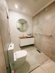 une salle de bain avec toilettes, lavabo et miroir dans l'établissement Modern 2 bedroom home in burwood east, à Burwood East