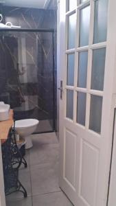 La salle de bains est pourvue d'une douche, de toilettes et d'une porte. dans l'établissement Vida & Brisa, à Pelotas