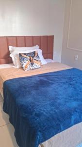 - un lit avec une couette bleue et 2 oreillers dans l'établissement Vida & Brisa, à Pelotas