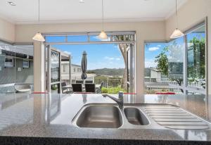 a kitchen with a sink and a large window at Cozy Water-View 2-Bdrm Suite in North Shore in Auckland