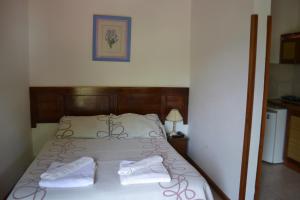 a bedroom with a bed with two towels on it at Rumi Huasi Cabañas in Mina Clavero