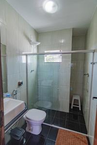 a bathroom with a toilet and a shower and a sink at Casa de Verão, 04 quartos todos com ar condicionado, 03 banheiros, churrasqueira e piscina para relaxar in Pirapora +15 photos
