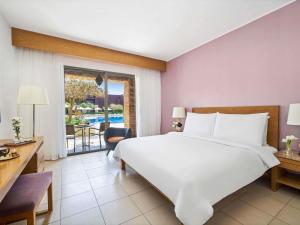 Un pat sau paturi într-o cameră la Mövenpick Resort & Spa Tala Bay Aqaba