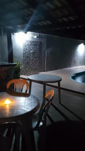 a table and chairs in a room with a tub at Casa de Verão, 04 quartos todos com ar condicionado, 03 banheiros, churrasqueira e piscina para relaxar in Pirapora