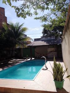 ein Swimmingpool vor einem Haus in der Unterkunft Casa de Verão, 04 quartos, 03 banheiros, piscina e churrasqueira para relaxar in Pirapora