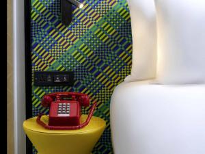 a red phone sitting on top of a yellow table at ibis Styles Bangkok Silom in Bangkok