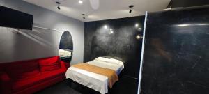 レオンにあるGiakor Suites - Gran Jardínのベッドと赤いソファのある寝室