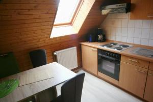 a kitchen with a stove and a table and a window at Wohnung In Ilfeld Mit Grill in Harztor