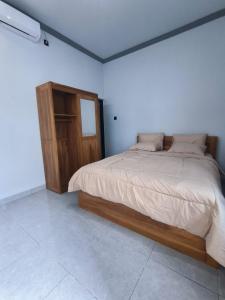 a bedroom with a large bed and a wooden cabinet at Gama Stay in Lovina