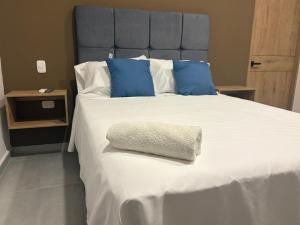 un grand lit avec des oreillers bleus et blancs dans l'établissement Hotel El Cedro Exclusive, à Florencia