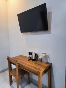a wooden table with a television on a wall at Gama Stay in Lovina