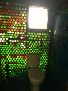 ein Badezimmer mit einer Wand, die mit Grün bedeckt ist, und grünen Bällen in der Unterkunft Casa de bambu e garrafas no litoral de Serra Grande in Uruçuca