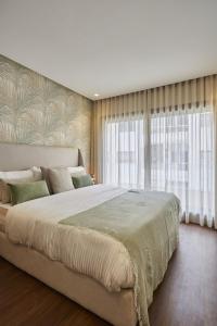 1 cama grande en un dormitorio con ventanas en Appartement ou Villa de charme à Taghazout Bay, en Agadir nʼ Aït Sa