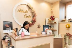 Una mujer sentada en un mostrador en una cafetería. en Fabiola Guest House, en Pompeya