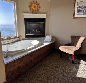 a large bath tub in a room with a fireplace at North Cliff Hotel in Fort Bragg