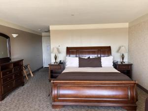 a bedroom with a bed and a dresser and a mirror at North Cliff Hotel in Fort Bragg