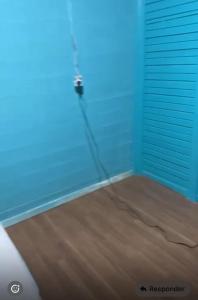 a room with blue walls and a door with a cord at Aconchegante demais in Macapá